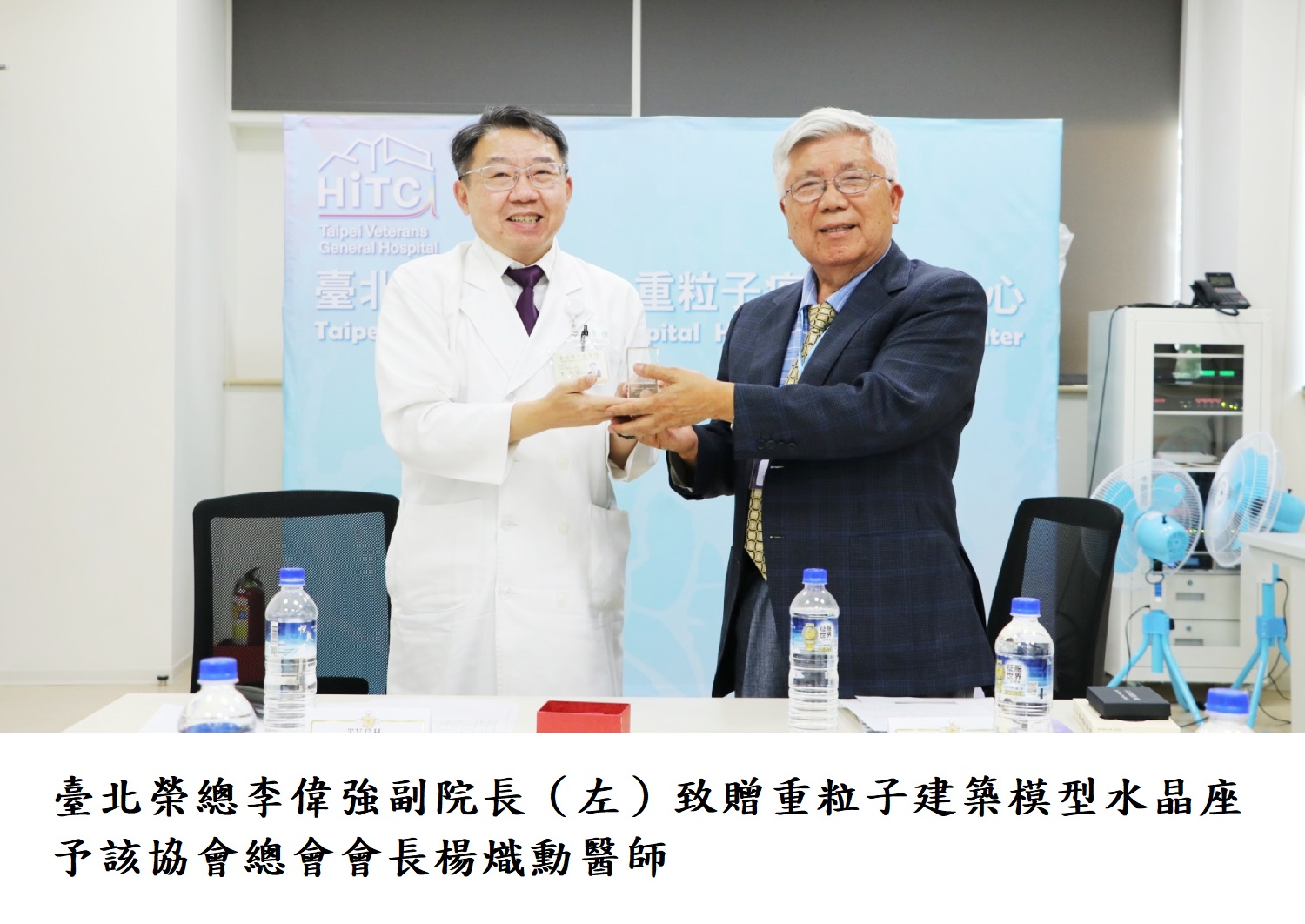 臺北榮總李偉強副院長（左）致贈重粒子建築模型水晶座予該協會總會會長楊熾勳醫師