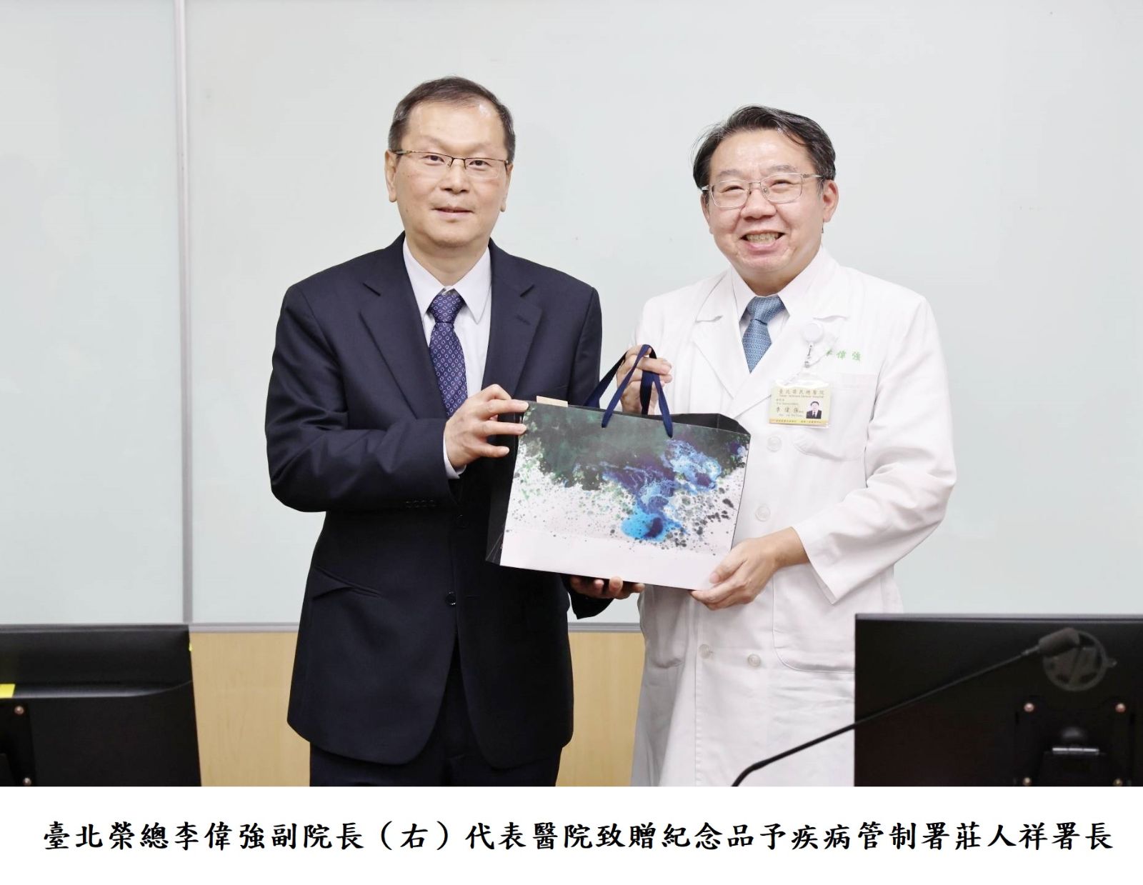 臺北榮總李偉強副院長（右）代表醫院致贈紀念品予疾病管制署莊人祥署長